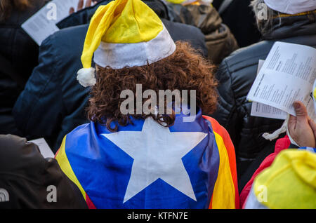 Barcellona, in Catalogna, Spagna. 24 dicembre, 2017. Un partecipante con il tradizionale cappello di Babbo Natale e il catalano independentist bandiera. Il catalano organizzazioni sovereigntists Omnium e ANC, hanno chiamato un canto di Natale per la libertà di fronte al Barcellona il Modelo di prigione. Diverse centinaia di persone hanno cantato tradizionali canzoni Natalizie nonché inni, in memoria dei membri del governo catalano sospeso ancora in carcere. Credito: Copyright Paco Freire/SOPA/ZUMA filo/Alamy Live News Foto Stock