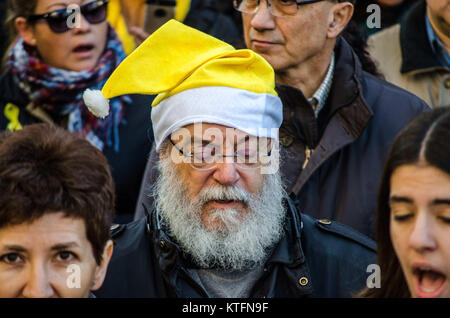 Barcellona, in Catalogna, Spagna. 24 dicembre, 2017. Uno dei partecipanti nelle canzoni di Natale con la tradizionale Santa Claus hat. Il catalano organizzazioni sovereigntists Omnium e ANC, hanno chiamato un canto di Natale per la libertà di fronte al Barcellona il Modelo di prigione. Diverse centinaia di persone hanno cantato tradizionali canzoni Natalizie nonché inni, in memoria dei membri del governo catalano sospeso ancora in carcere. Credito: Copyright Paco Freire/SOPA/ZUMA filo/Alamy Live News Foto Stock