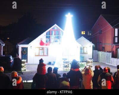 Warden Bay, Kent, Regno Unito. 24 dicembre, 2017. Una casa in Warden Bay mette su una spettacolare la vigilia di Natale display luci dotate di una struttura realizzata da luci più alti di quelli della casa che visualizza varie controllate dal computer degli schemi di illuminazione a tempo di musica. Circa 75-100 persone uscì a guardare il display a 7pm, che dura per circa 30 minuti. Tutte le donazioni sono date per il SNAAP (Esigenze particolari Advisory & Attività Progetto) di carità per bambini disabili. Credito: James Bell/Alamy Live News Foto Stock