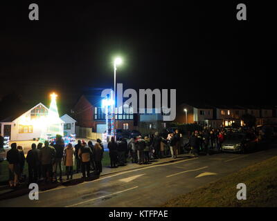 Warden Bay, Kent, Regno Unito. 24 dicembre, 2017. Una casa in Warden Bay mette su una spettacolare la vigilia di Natale display luci dotate di una struttura realizzata da luci più alti di quelli della casa che visualizza varie controllate dal computer degli schemi di illuminazione a tempo di musica. Circa 75-100 persone uscì a guardare il display a 7pm, che dura per circa 30 minuti. Tutte le donazioni sono date per il SNAAP (Esigenze particolari Advisory & Attività Progetto) di carità per bambini disabili. Credito: James Bell/Alamy Live News Foto Stock