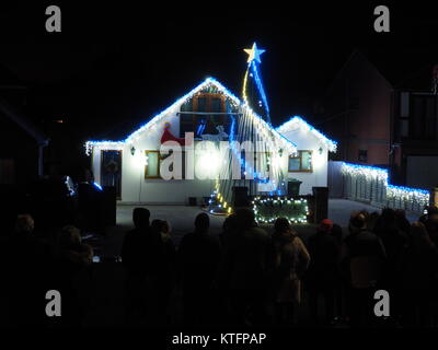 Warden Bay, Kent, Regno Unito. 24 dicembre, 2017. Una casa in Warden Bay mette su una spettacolare la vigilia di Natale display luci dotate di una struttura realizzata da luci più alti di quelli della casa che visualizza varie controllate dal computer degli schemi di illuminazione a tempo di musica. Circa 75-100 persone uscì a guardare il display a 7pm, che dura per circa 30 minuti. Tutte le donazioni sono date per il SNAAP (Esigenze particolari Advisory & Attività Progetto) di carità per bambini disabili. Credito: James Bell/Alamy Live News Foto Stock