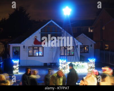 Warden Bay, Kent, Regno Unito. 24 dicembre, 2017. Una casa in Warden Bay mette su una spettacolare la vigilia di Natale display luci dotate di una struttura realizzata da luci più alti di quelli della casa che visualizza varie controllate dal computer degli schemi di illuminazione a tempo di musica. Circa 75-100 persone uscì a guardare il display a 7pm, che dura per circa 30 minuti. Tutte le donazioni sono date per il SNAAP (Esigenze particolari Advisory & Attività Progetto) di carità per bambini disabili. Credito: James Bell/Alamy Live News Foto Stock