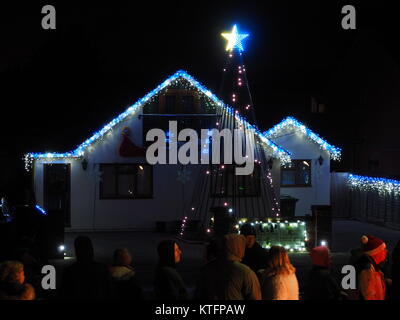 Warden Bay, Kent, Regno Unito. 24 dicembre, 2017. Una casa in Warden Bay mette su una spettacolare la vigilia di Natale display luci dotate di una struttura realizzata da luci più alti di quelli della casa che visualizza varie controllate dal computer degli schemi di illuminazione a tempo di musica. Circa 75-100 persone uscì a guardare il display a 7pm, che dura per circa 30 minuti. Tutte le donazioni sono date per il SNAAP (Esigenze particolari Advisory & Attività Progetto) di carità per bambini disabili. Credito: James Bell/Alamy Live News Foto Stock