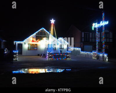 Warden Bay, Kent, Regno Unito. 24 dicembre, 2017. Una casa in Warden Bay mette su una spettacolare la vigilia di Natale display luci dotate di una struttura realizzata da luci più alti di quelli della casa che visualizza varie controllate dal computer degli schemi di illuminazione a tempo di musica. Circa 75-100 persone uscì a guardare il display a 7pm, che dura per circa 30 minuti. Tutte le donazioni sono date per il SNAAP (Esigenze particolari Advisory & Attività Progetto) di carità per bambini disabili. Credito: James Bell/Alamy Live News Foto Stock