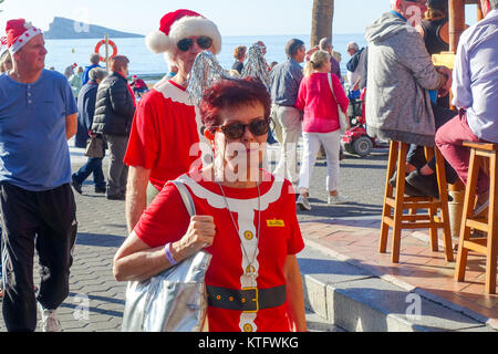 Benidorm, Costa Blanca, Spagna, 25 dicembre 2017. Temperature elevate in provincia di Alicante per il periodo natalizio. British vacanzieri in Santa tute cappelli, ponticelli festeggiano il Natale passeggiando lungo la promenade e nel Lungomare di barre di Benidorm. Credito: Mick Flynn/Alamy Live News Foto Stock