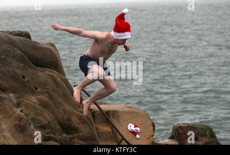 Sandycove, Irlanda. Il 25 dicembre 2017. Un uomo prende parte alla tradizione annuale di saltare in quaranta piedi, un open-sea area balneare, a Sandycove, Co Dublin. Credito : Laura Hutton/Alamy Live News. Foto Stock