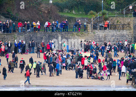 Tenby, Pembrokeshire, West, Wales, Regno Unito. Il 26 dicembre 2017. Centinaia di persone si prendono parte all'annuale Boxing Day nuotare questa mattina in costume a 11:30, mentre centinaia di più essere spettatori. Ora si tratta di 47th anno si solleva per migliaia di carità. Credito: Andrew Bartlett/Alamy Live News. Foto Stock