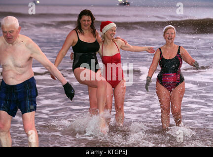 Erri Malmaison Doherty (centro) e Estelle Zauner Maughan (centro sinistra) del re Edward's Bay nuotatori godere di un giorno di Natale Dip all'alba, al King Edward's Bay, Newcastle. Foto Stock