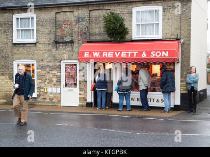 Le persone al di fuori della coda e W Revett e figlio macelleria, Wickham Mercato, Suffolk, Inghilterra, Regno Unito Foto Stock