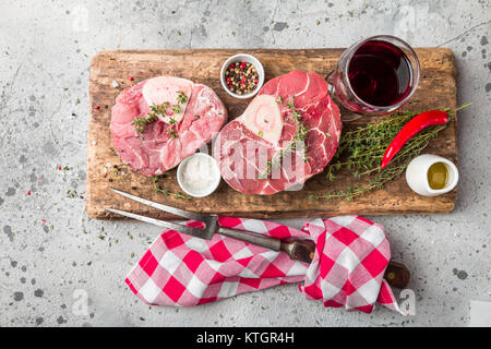 Freschi Stinco di vitello fette di carne di manzo per osso buco per la cottura sul tagliere con ingredienti e condimenti timo, pepe, sale. Foto Stock