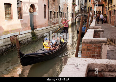 Famiglia asiatica ride giro in gondola a Venezia / Italia. Vecchi edifici storici in background. Foto Stock