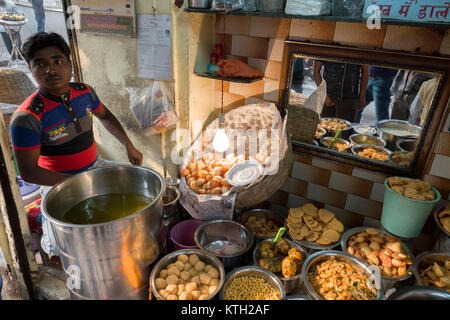 L'uomo la vendita di cibo di strada da stallo nella Vecchia Delhi, India Foto Stock