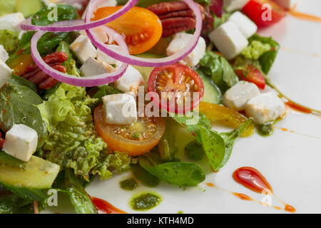 Insalata verde con il formaggio feta , le noci e pesto. Foto Stock