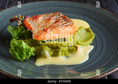 Fritti di filetto di salmone con foglie di insalata e salsa di panna e decorate con caviale Foto Stock