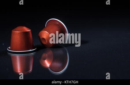 Rosso di caffè espresso capsule isolati su sfondo nero, Closeup vista con dettagli, spazio per il testo Foto Stock