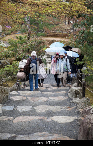 Giappone, Kyoto-CIRCA APR, 2013: visitatori asiatici con ombrelloni a piedi la zona di Kinkaku-ji il santuario. Scala è sul territorio di Rokuon-ji o Golden Pavili Foto Stock