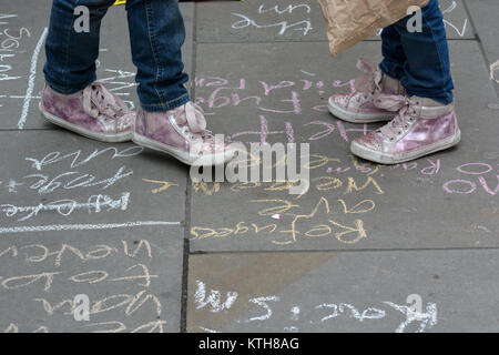 "I rifugiati sono benvenuti qui" e "Aiutare i bambini rifugiati" i messaggi vengono scritti sul marciapiede da bambini che protestavano contro il razzismo, Londra, Regno Unito. Foto Stock