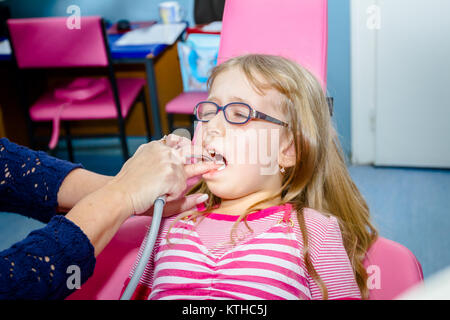 Frightened sweet little girl con bocca aperta è in studio dentistico, cure dentarie. Foto Stock