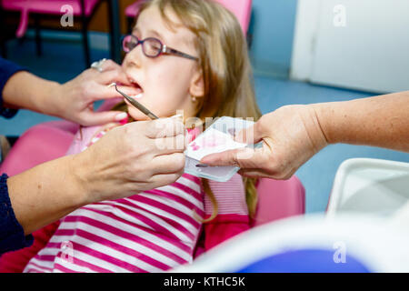 Frightened sweet little girl con bocca aperta è in studio dentistico, cure dentarie. Foto Stock