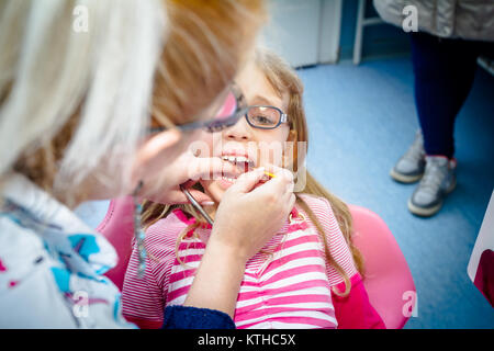 Frightened sweet little girl con bocca aperta è in studio dentistico, cure dentarie. Foto Stock