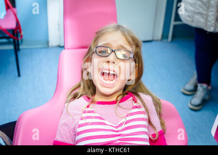 Frightened sweet little girl con bocca aperta è in studio dentistico, cure dentarie. Foto Stock