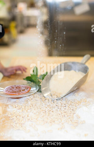 Donna fare e preparare pisarei gnocchi di pasta tipico da Emilia Romagna, Piacenza, Italia presso il ristorante cucina preparazione Foto Stock