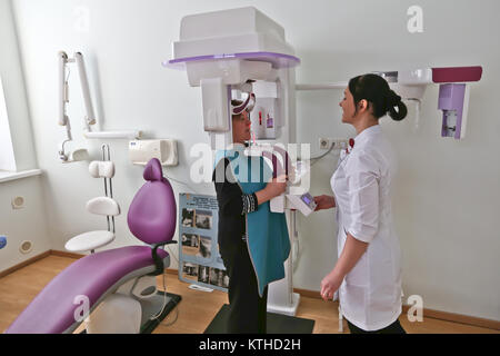 Close up colpo alla testa della ragazza tenendo tac dentale con panorama cefalometriche macchina a raggi x in clinica Foto Stock