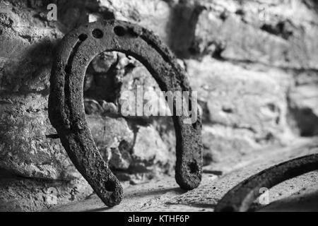 Vecchio arrugginito sorge a ferro di cavallo vicino a un muro di mattoni, vicino la foto con il fuoco selettivo Foto Stock