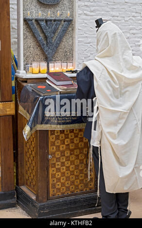 Un Ebreo non identificato uomo prega da solo al mattino i servizi in una sinagoga in Crown Heights, Brooklyn, New York City. Foto Stock