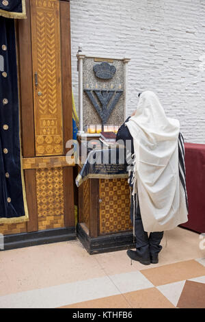 Un Ebreo non identificato uomo prega da solo al mattino i servizi in una sinagoga in Crown Heights, Brooklyn, New York City. Foto Stock