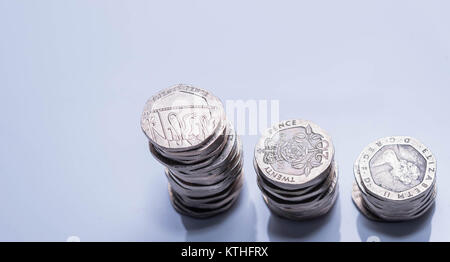 Pile di differenti monete Britanniche su uno sfondo bianco. Foto Stock