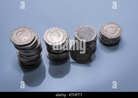 Pile di differenti monete Britanniche su uno sfondo bianco. Foto Stock