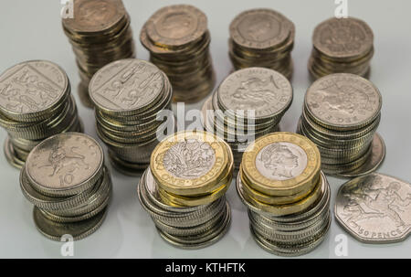 Pile di differenti monete Britanniche su uno sfondo bianco. Foto Stock