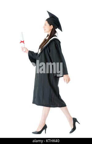 Elegante bellezza ragazza studente getting laureato dall'università a camminare su sfondo bianco che mostra immettere al concetto Workplace. Foto Stock