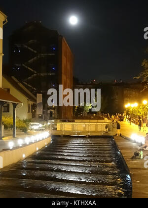 Una fotografia della notte del 13 luglio 2013, che mostra la pittoresca città di Miedzywodzie, Polonia. L'immagine cattura la bellezza serena della città costiera di notte, con le luci che si riflettono sull'acqua. Foto Stock