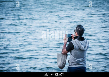 Medio Oriente uomo prendendo foto di mare Foto Stock