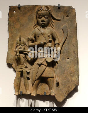 Questa targa del Benin, esposta nel Museo Etnologico di Berlino, è un esempio delle sofisticate tradizioni di fusione del bronzo del Regno del Benin nell'Africa occidentale. Le targhe raffigurano importanti figure storiche e reali. Foto Stock