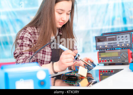 Schoolgirl in robot di laboratorio microcontrollore di debug Foto Stock