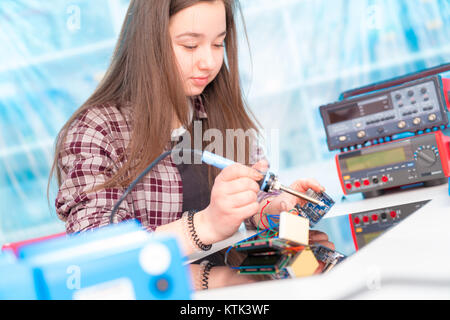 Schoolgirl in robot di laboratorio microcontrollore di debug Foto Stock