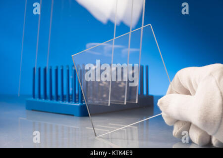 Vetro antiproiettile nel laboratorio di ottica. Controllare le proprietà ottiche del vetro temprato Foto Stock