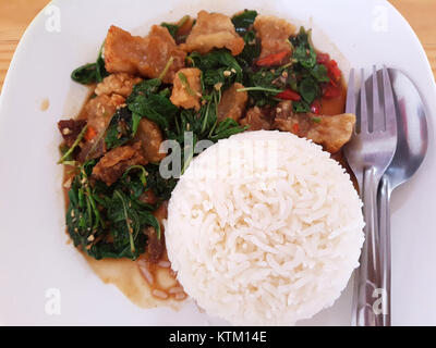 Il maiale croccante fritto al basilico con riso, fotografato a Chiang mai nel 2017, è un popolare piatto tailandese. Conosciuto per i suoi sapori saporiti, il piatto combina maiale croccante con basilico aromatico e un lato di riso al vapore, offrendo un assaggio esclusivo della cucina thailandese del nord. Foto Stock