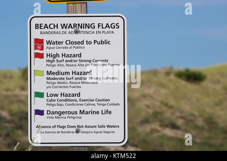 Un cartello segnaletico sulla spiaggia serve come misura di sicurezza per informare il pubblico di potenziali pericoli sulla spiaggia, tra cui forti correnti, onde alte o pericolose forme di vita marina, garantendo la sicurezza degli amanti della spiaggia. Foto Stock