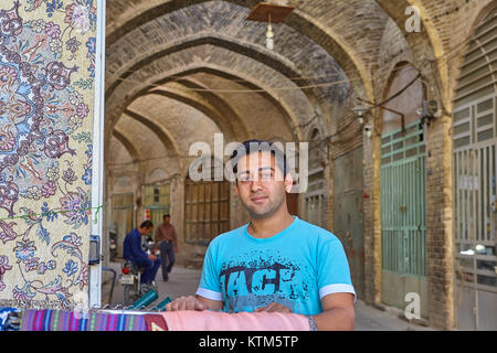 Yazd, Iran - 22 Aprile 2017: Ritratto di un giovane uomo iraniano vendita di tappeti e tessuti nel bazar orientale. Foto Stock