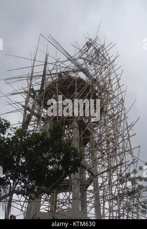 L'impalcatura in bambù è comunemente utilizzata nelle costruzioni, in particolare in Asia, grazie alla sua resistenza e flessibilità. Questa immagine raffigura un'impalcatura di bambù che circonda una torre d'acqua, mostrando un metodo di costruzione tradizionale ancora utilizzato nella costruzione moderna. Foto Stock