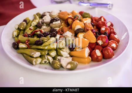 Antipasti antipasto ciliegio dolce mini peperoni ripieni di formaggio a pasta morbida feta su una piastra bianca Foto Stock