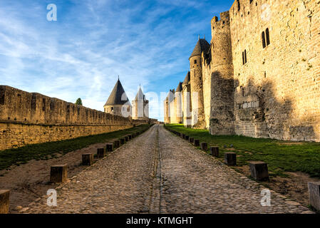 Antiche strade tra le mura di fortificazione medievale sotto nuvolosi cieli blu Foto Stock
