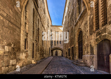 Strada di ciottoli tra alte pareti in una città medievale Foto Stock