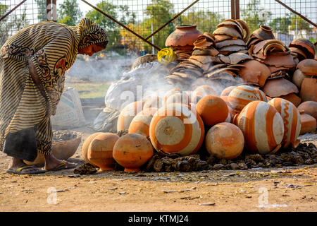 Una donna potter disponendo pentole per la cottura Foto Stock