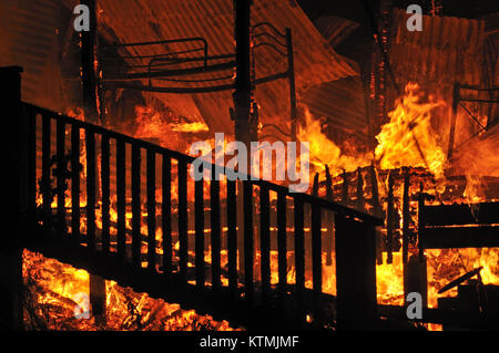 Le fiamme e il fumo salire dalla casa in fiamme Foto Stock