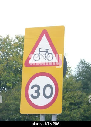Un segnale combinato di avviso di percorso ciclabile e di limite di velocità di 30 km/h si trova a Liphook, Hampshire. Questo segnale indica sia la presenza di una pista ciclabile che di una limitazione di velocità per i veicoli, promuovendo la sicurezza sia per i ciclisti che per i conducenti. Foto Stock